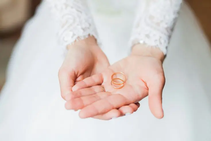 A woman's hands holding two rings