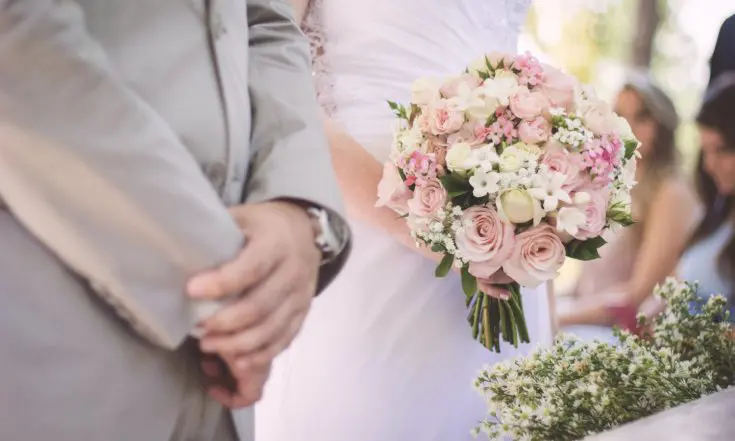 The hands of a bride and groom at the altar
