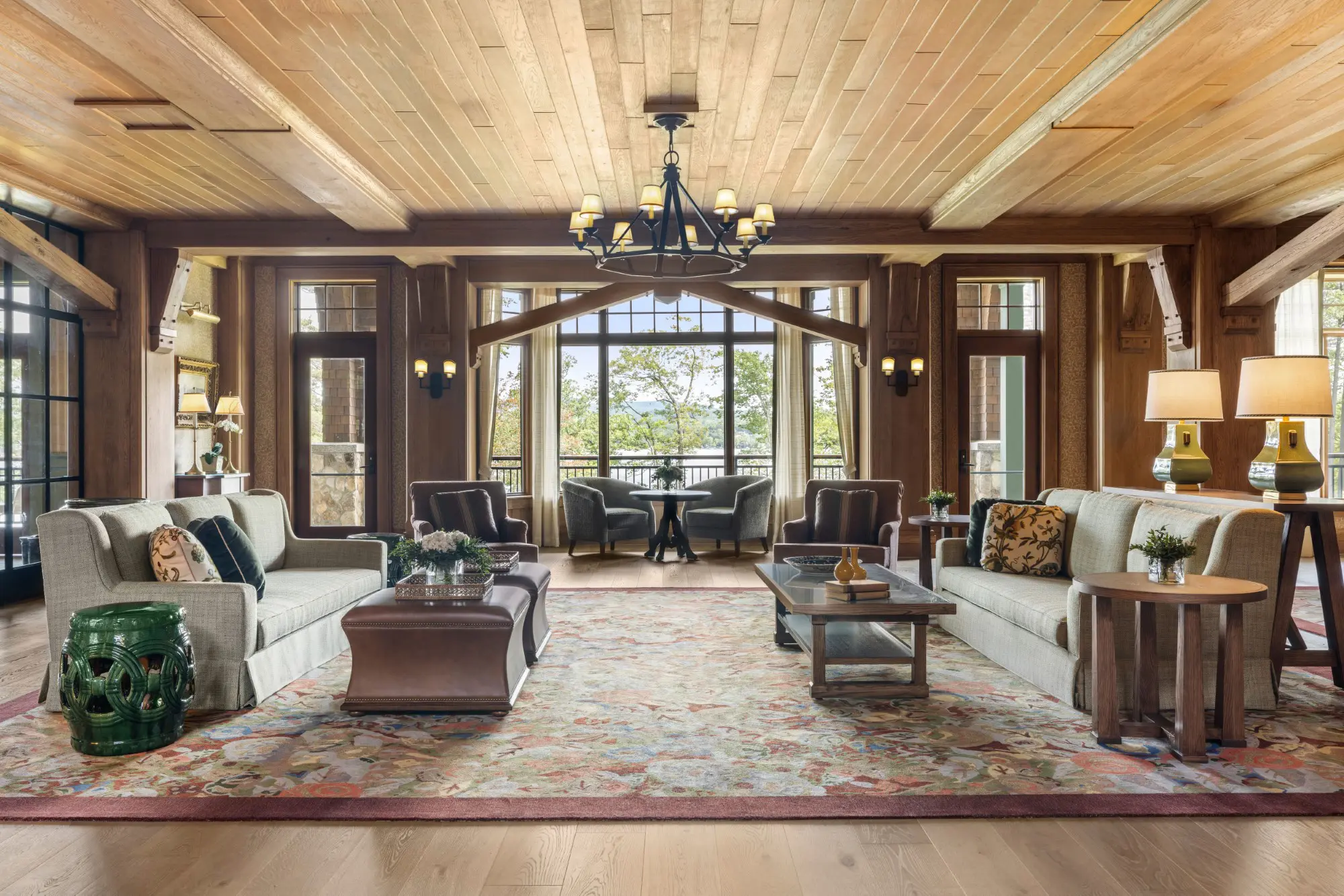 Rustic lounge with wood ceiling, chandeliers, and sofas