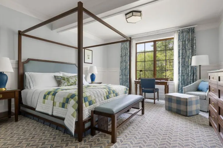 Suite bedroom with four-poster king bed and desk