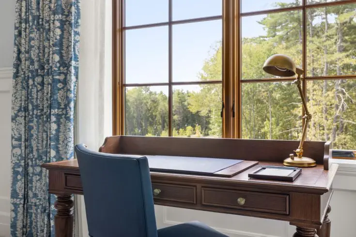 Writing desk with blue chair and window view