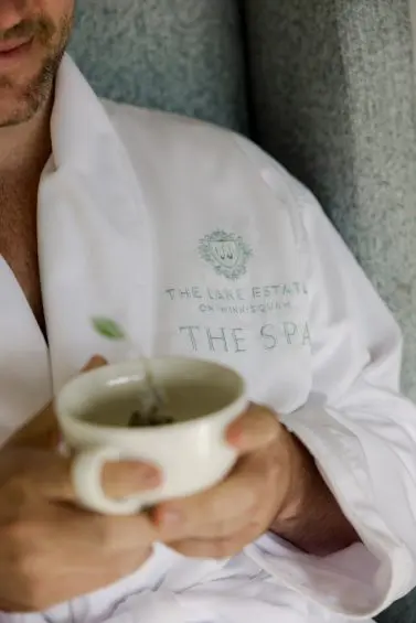 Guest holding tea in robe at The Lake Estate Spa.