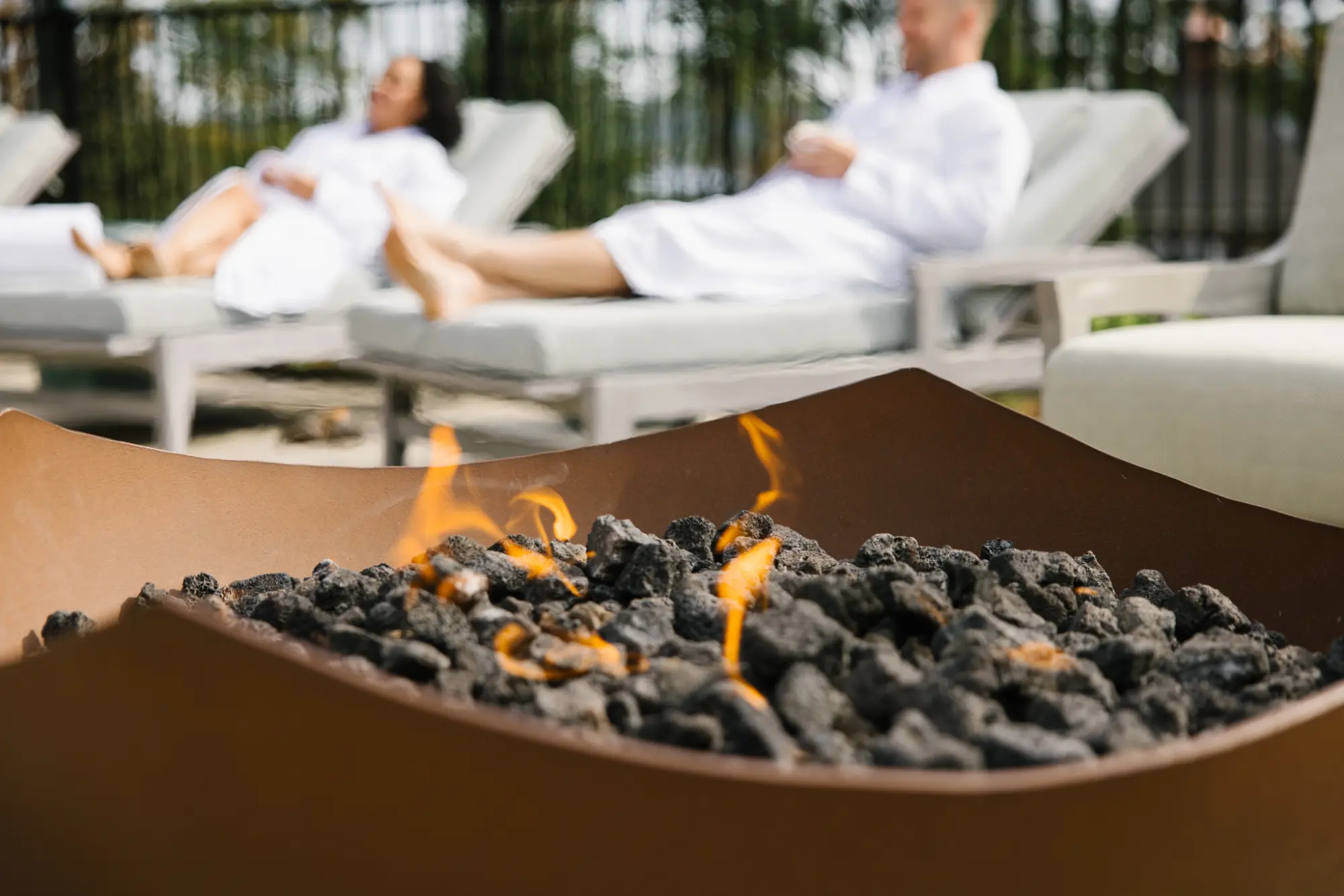 Fire pit near spa lounge chairs at The Lake Estate.