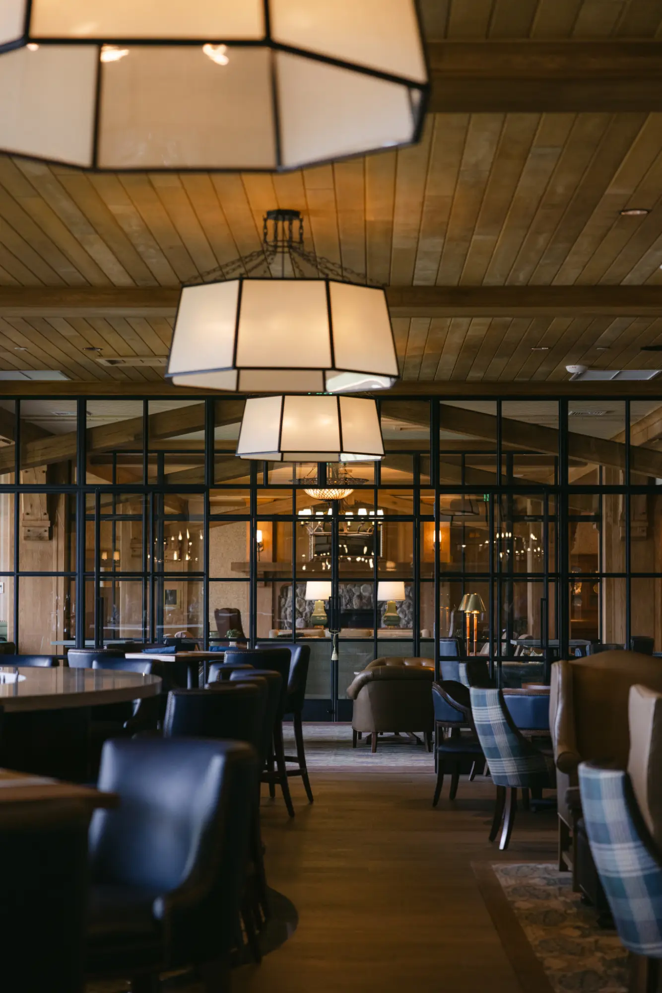 Lounge seating under warm pendant lights and wood ceiling.