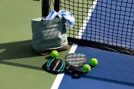 Pickleball paddles and balls on court.