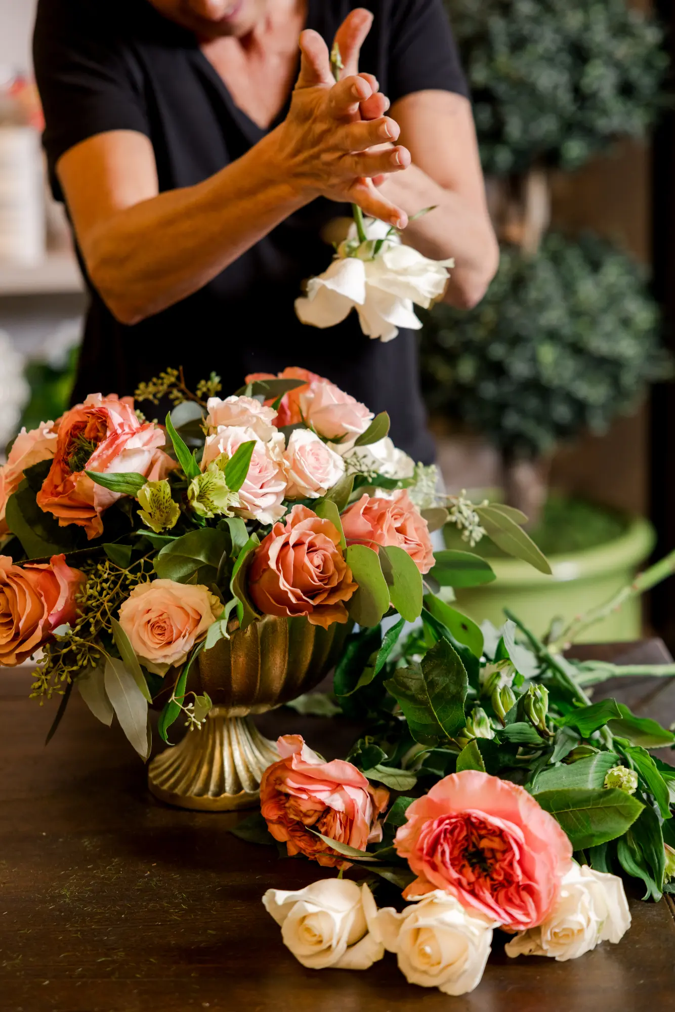 Floral designer arranging a bouquet of roses.