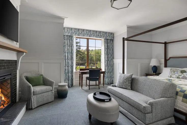 Guest room featuring a four-poster bed, fireplace, spacious seating area, and scenic views