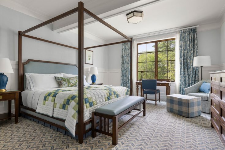 Suite bedroom with four-poster king bed and desk